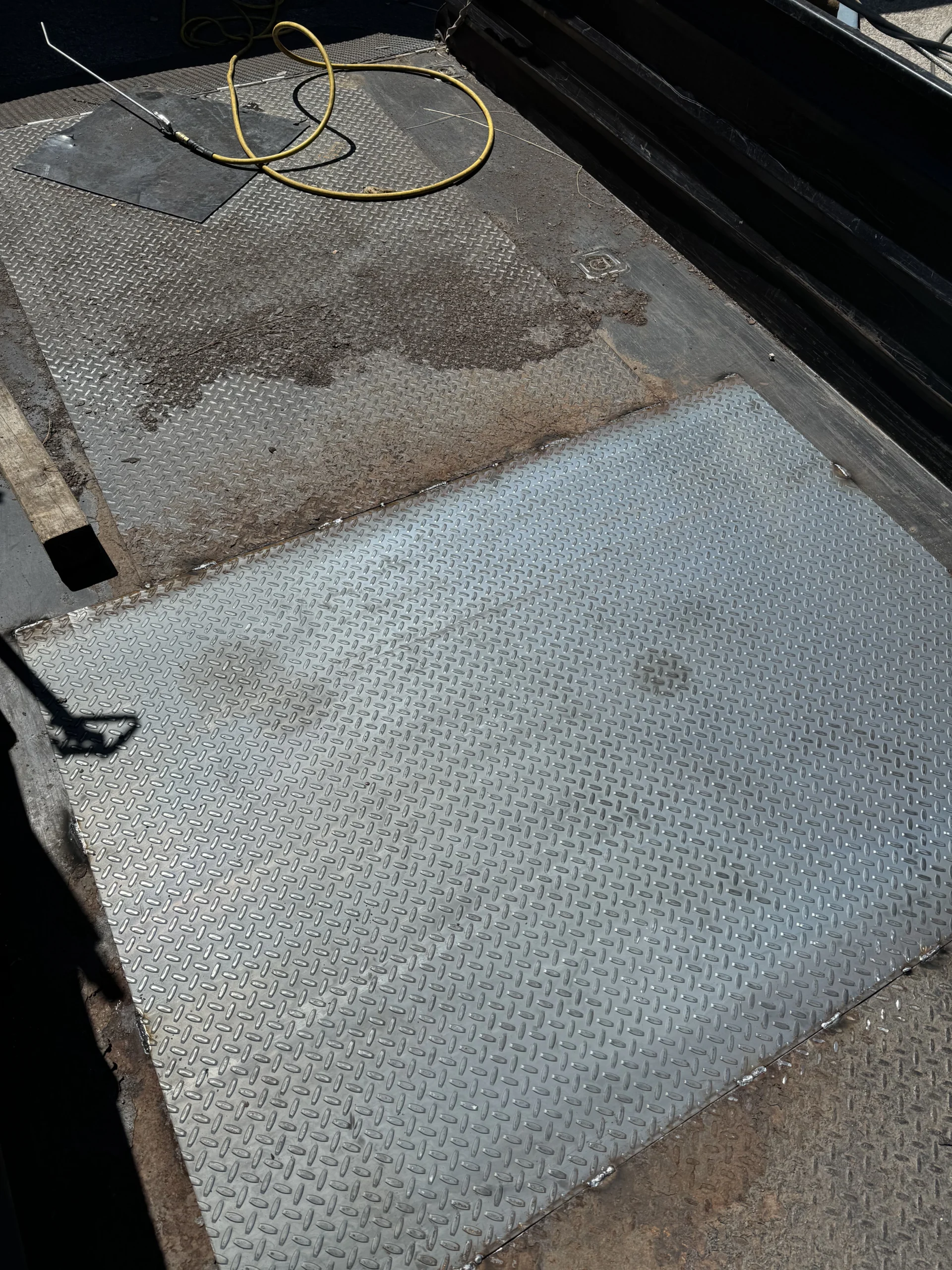 New diamond plate steel floor panel welded into a trailer deck during a trailer repair